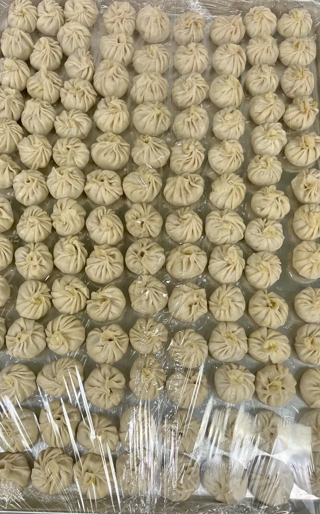 a tray of uncooked momos.